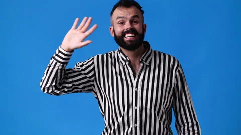 4k slow motion video of one man waving hello on blue background. Video stock 227424369
