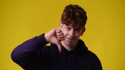 4k slow motion video of one man showing thumb down on yellow background. Video stock 227521238