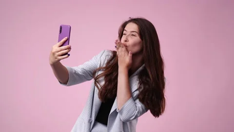 4k slow motion video of one girl making selfie on pink background. Stock Footage 228689288