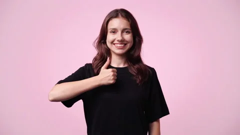 4k slow motion video of one girl showing thumb up on pink background. Stock Footage 228716896