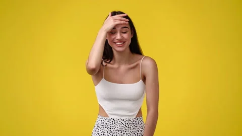 4k slow motion video of one girl pointing at the camera and smiling over yellow Stock Footage 228720929