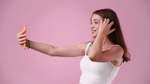 4k slow motion video of one girl having a videocall on pink background. Stock Footage 228756189