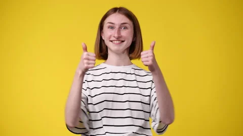 4k slow motion video of one girl showing thumbs up on yellow background. Stock Footage 228760844