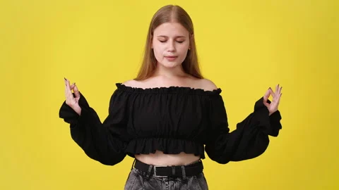 4k slow motion video of one girl meditating on yellow background. Stock Footage 229130289