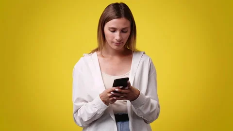 4k slow motion video of one girl sending messages on yellow background. Stock Footage 229308734