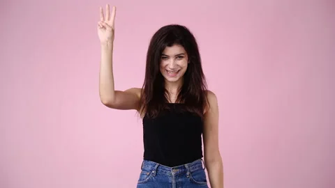 4k slow motion video of one girl counting till three over pink background. Stock Footage 229650988
