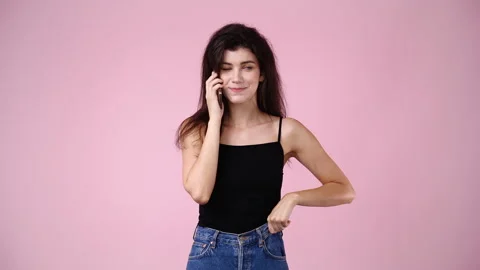 4k slow motion video of one girl talking over the phone on pink background. Stock Footage 229652999