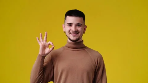 4k slow motion video of one man showing OK sign on yellow background. Stock Footage 229703009