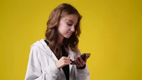 4k slow motion video of one girl sending messages on yellow background. Stock Footage 229774297