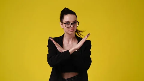 4k slow motion video of one girl with crossed hands on yellow background. Stock Footage 229978893
