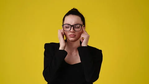 4k slow motion video of one girl having headache over yellow background. Stock Footage 229984871