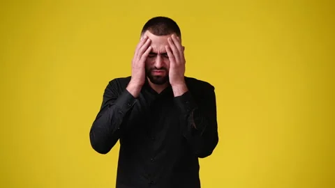 4k slow motion video of one man having headache over yellow background. Video stock 229988854