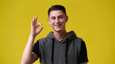 4k slow motion video of one man showing OK sign on yellow background. Stock Footage 229992385