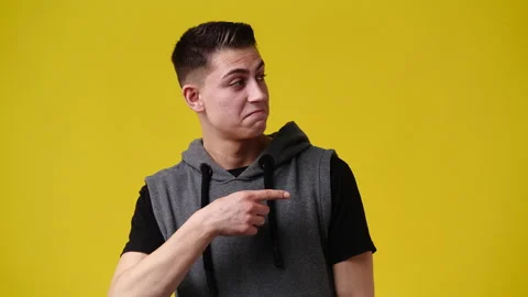 4k slow motion video of one man pointing at right and showing thumb up on yellow Stock Footage 229993251