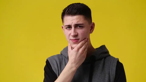 4k slow motion video of one man touching his chin over yellow background. Stock Footage 229994517