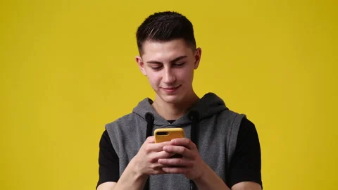 4k slow motion video of one man using phone over yellow background. Stock Footage 230410867