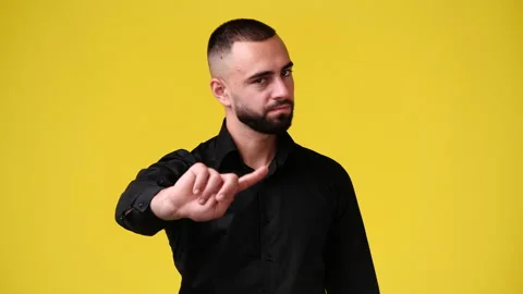 4k slow motion video of one man showing stop sign over yellow background. Stock Footage 230414857