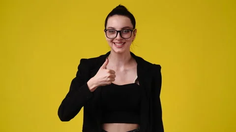 4k slow motion video of one girl showing thumb up over yellow background. Stock Footage 230659344