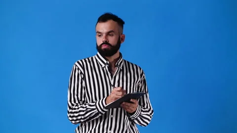 4k slow motion video of one man taking notes over blue background. Stock Footage 230665399
