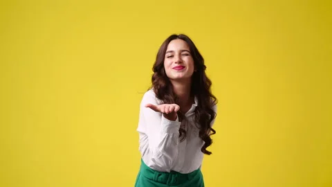 4k slow motion video of one girl sending an air kiss on yellow background. Stock Footage 231131719