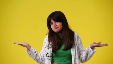 4k slow motion video of one girl with uncertain facial expression over yellow Video stock 231140820