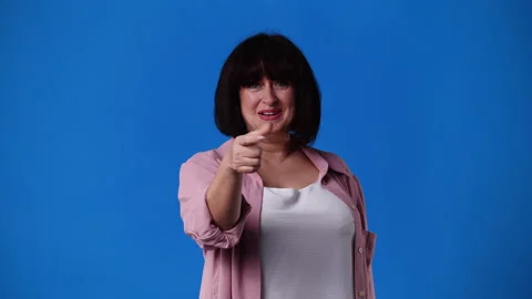 4k slow motion video of one woman showing call me sign over blue background. Stock Footage 231330737