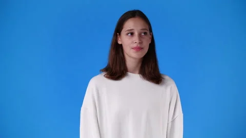 4k slow motion video of one girl showing silence sign over blue background. Video stock 231338374