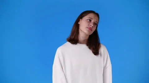 4k slow motion video of one girl with negative facial expression over blue Stock Footage 231339428