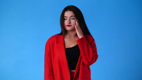 4k slow motion video of one tired woman holds one hand to her head over blue Stock Footage 234998565