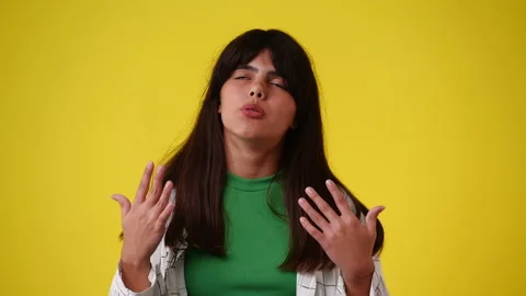 4k slow motion video of one girl cooled by his hands over yellow background. Stock Footage 235453853