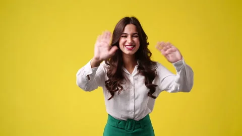 4k slow motion video of one girl says hello to someone over yellow background. Stock Footage 235456143