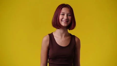 4k slow motion video of one girl who posing and smiling over yellow background. Stock Footage 235469526