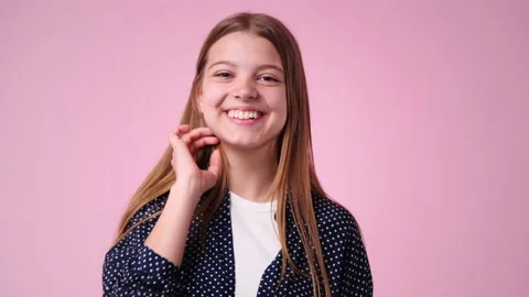 4k slow motion video of one girl fixes her hair and smiles sweetly over pink Stock Footage 236651339