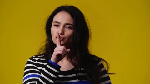4k slow motion video of one woman showing silence sign over yellow background. Stock Footage 237706109