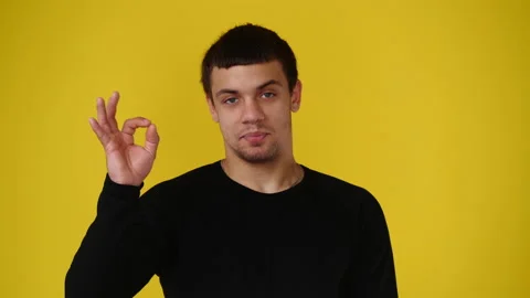 4k slow motion video of one man who showing an OK sign over yellow background. Stock Footage 237710322