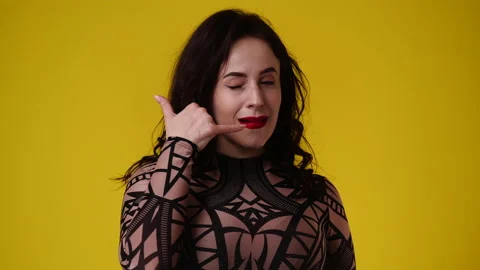 4k slow motion video of one woman asks to call someone over yellow background. Vidéo 237746066