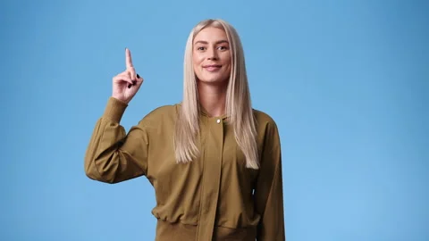 4k slow motion video of one woman points upwards on blue background. Stock Footage 238444214