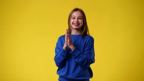 4k slow motion video of one girl claps his hands and smiling over yellow Stock Footage 238453982
