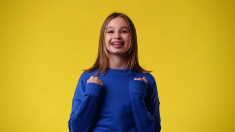 4k slow motion video of one girl emotionally rejoices over yellow background. Stock Footage 238454264