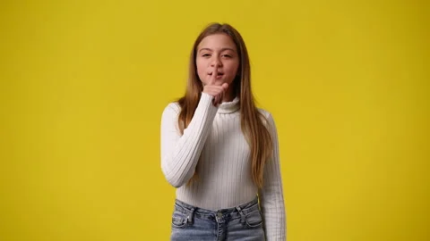 4k slow motion video of one young girl looks around and showing silence sign Stock Footage 241431986