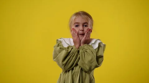 4k slow motion video of one kid who is surprised over yellow background. Stock Footage 241432606