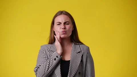 4k slow motion video of one woman who suffers from toothache over yellow Stock Footage 243312259
