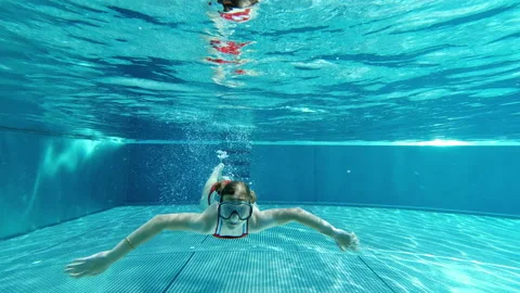 4K slow motion video of portrait of cute little girl diving in swimming pool Stock Footage 201350879