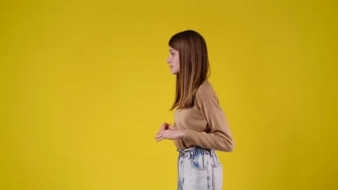 4k slow motion video of side view of one girl dancing over yellow background. Stock Footage 230158918