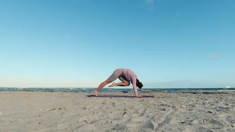 4k slow motion video of young female doing morning yoga routine  at the beach Video stock 205584864