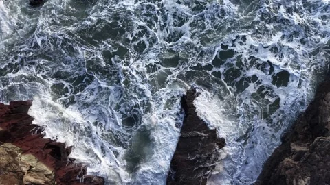 4K Slow Motion Waves Crashing on Dark Rocks Stockbeeldmateriaal 333707926