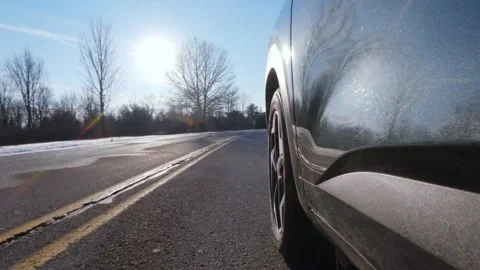 4K Slow Motion Wheel Shot of a Car Driving on Snowy Winter Roads Stock Footage 300147917