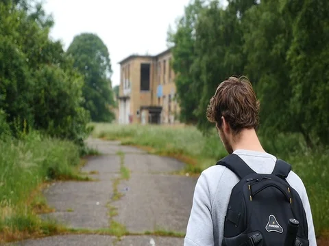 4K Slowmotion man walking through abandoned military base. 스톡 동영상 70319289