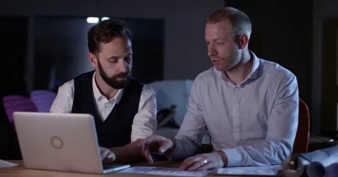 4K Small business partners working late in the office, going over the finances Stock Footage 76733138