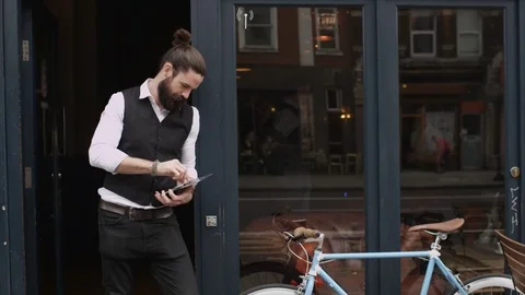 4K Smiling Bar Or Cafe Owner Holds Up A Sign To Show He Is Open For Business Stock Footage 75703420
